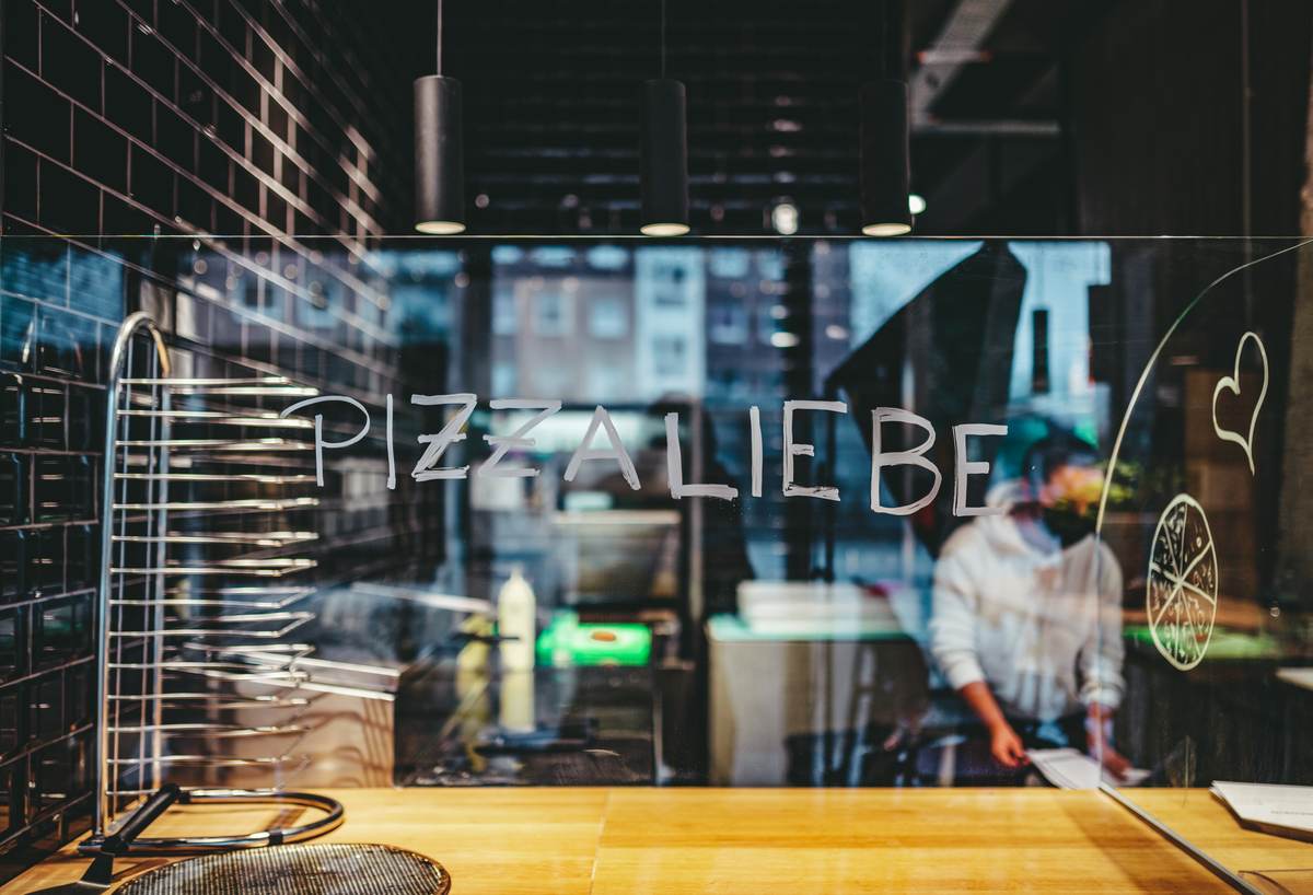 Schriftzug Pizzaliebe an der Scheibe der Showküche